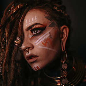 Dread loctician, model, photographer, and sustainable/slow fashion supporter modeling a Copper Ashes ethically sourced bone and ammonite fossil dreadlock bead.